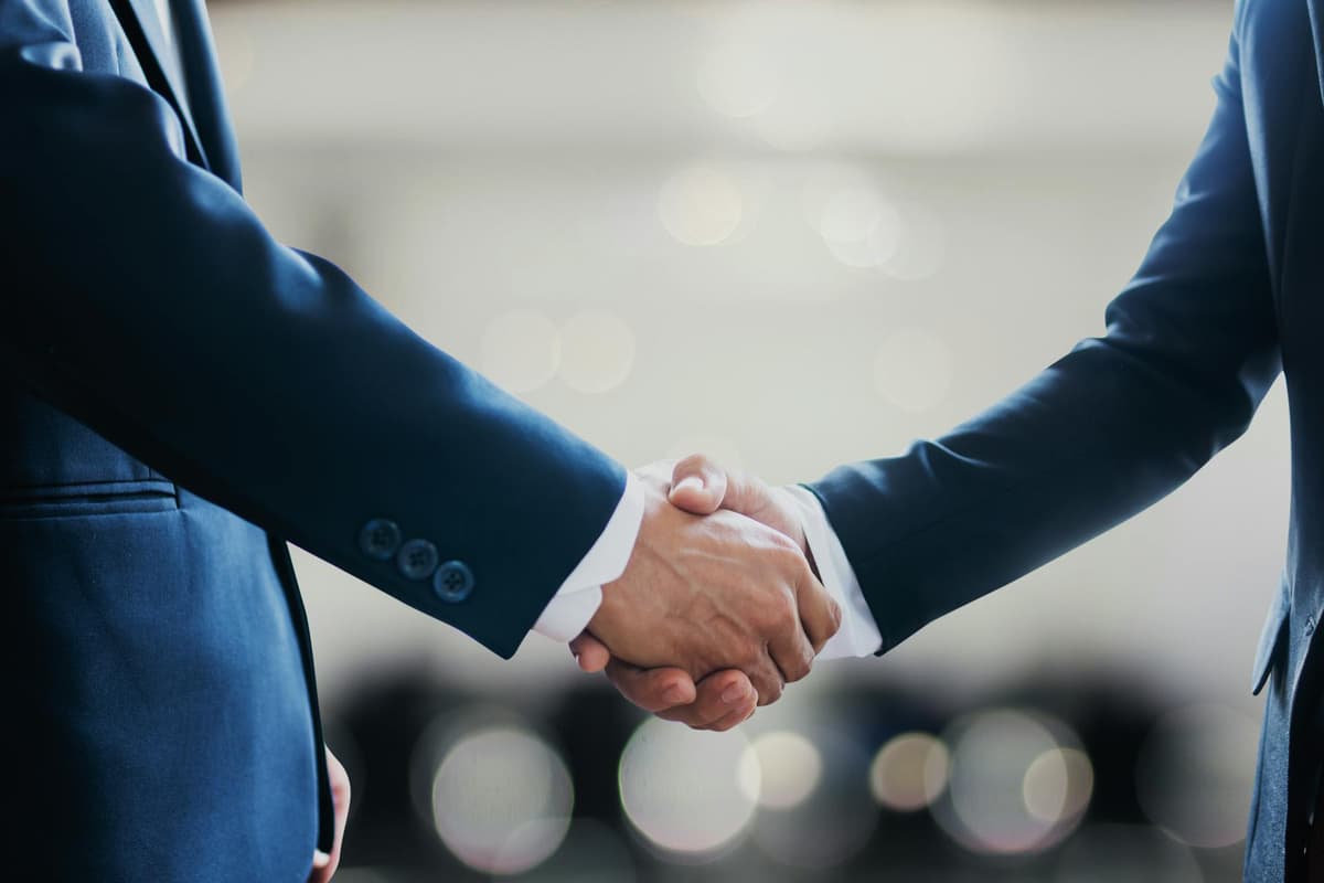 Business handshake between two professionals in suits, symbolizing partnership and collaboration